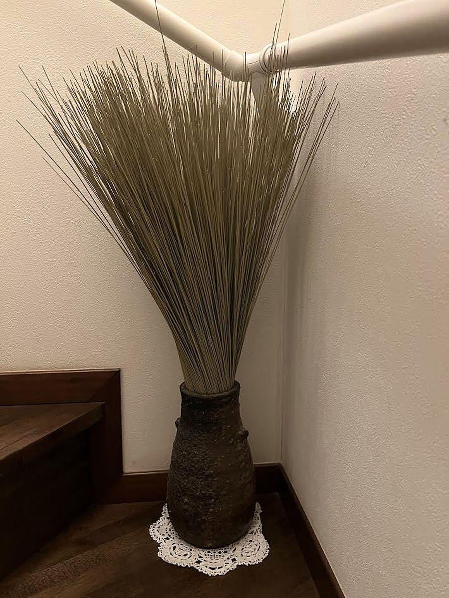 レースの敷物の上に置かれた、ドライグラスを生けた背の高い花器